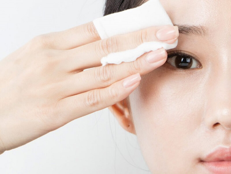 Vệ sinh mí mắt bằng cách dùng bông tẩy trang chấm vào nước muối để lau sạch