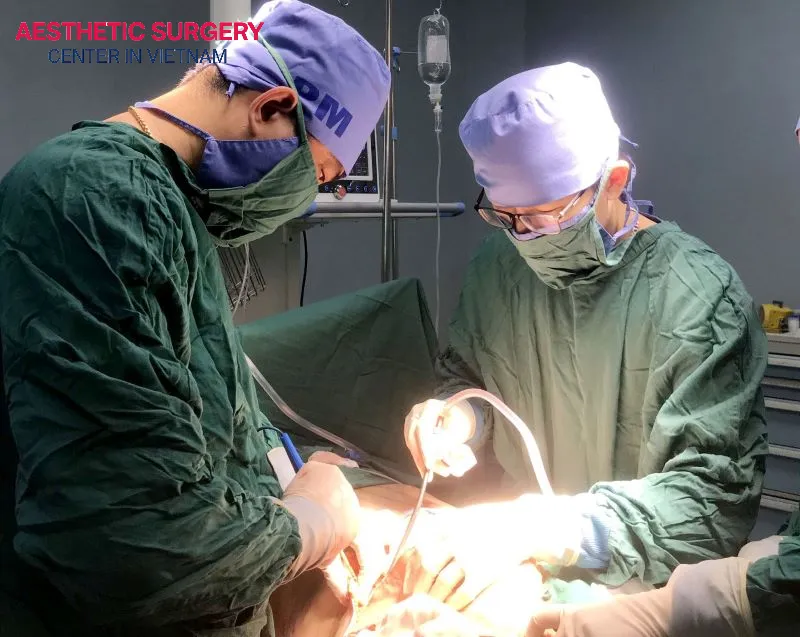 The doctor is performing liposuction on the client's waist to remove excess fat