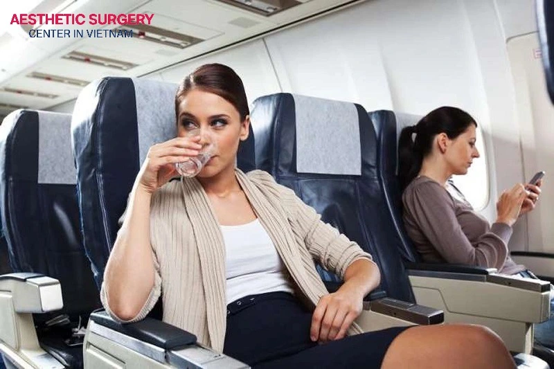 Maintain adequate hydration to support circulation and wound healing when flying after breast surgery.