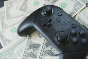 a video game controller sitting on top of a pile of money