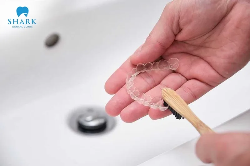 Regularly rinse the trays with warm water and brush them clean with a soft toothbrush and toothpaste