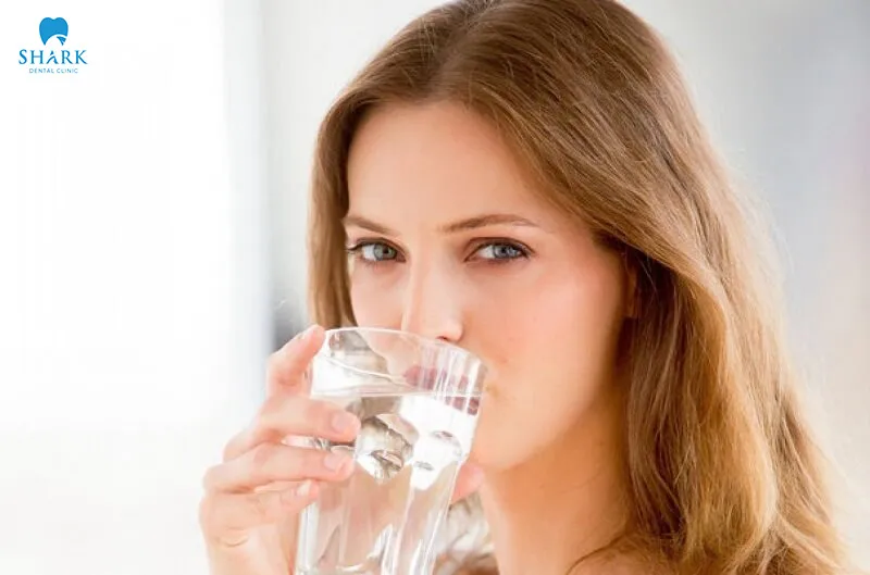 Drink plenty of water after veneer placement, prioritizing plain water while limiting alcoholic beverages and dark-colored drinks that may affect the color of the veneers