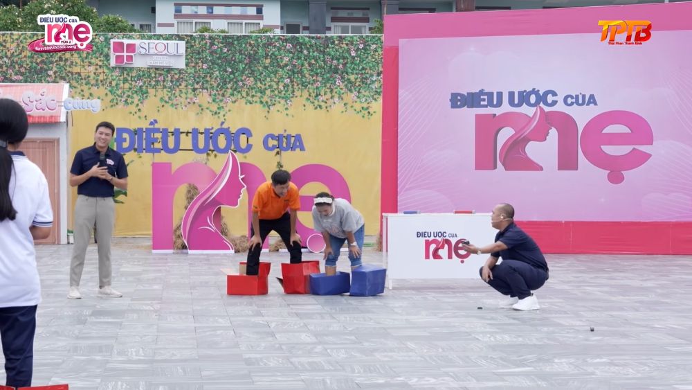 Trong trò chơi “Khóa hy vọng”, hai đội cùng xỏ chân vào thùng nhựa và lăn bánh xe xích để đua tiếp sức, thử thách sự khéo léo và phối hợp ăn ý