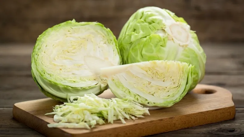 bắp cải tươi được cắt đôi và thái sợi, minh họa loại rau xanh thường được sử dụng trong chế độ dinh dưỡng sau nâng mũi.