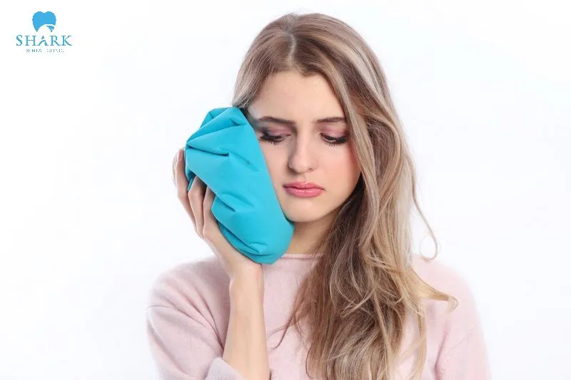 Chườm đá lạnh để giảm sưng sau khi nhổ răng khôn