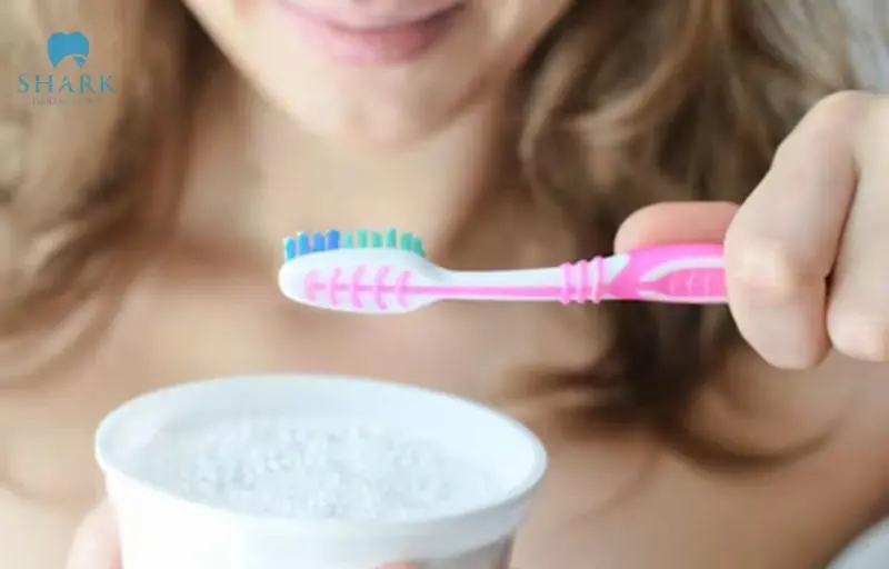 Sử dụng bàn chải đánh răng với bột hoặc kèm làm trắng răng