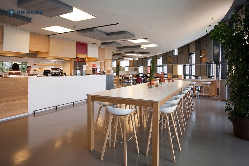 Thiết kế pantry văn phòng bố trí nhiều bàn ghế và quầy bar đầy đủ dụng cụ pha chế cần thiết