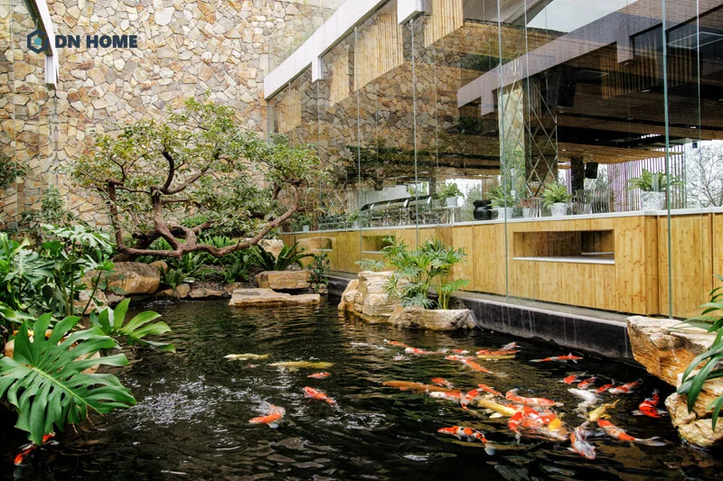 Quán cà phê cá koi với tường kính bao quanh hồ, ánh sáng tự nhiên tràn ngập