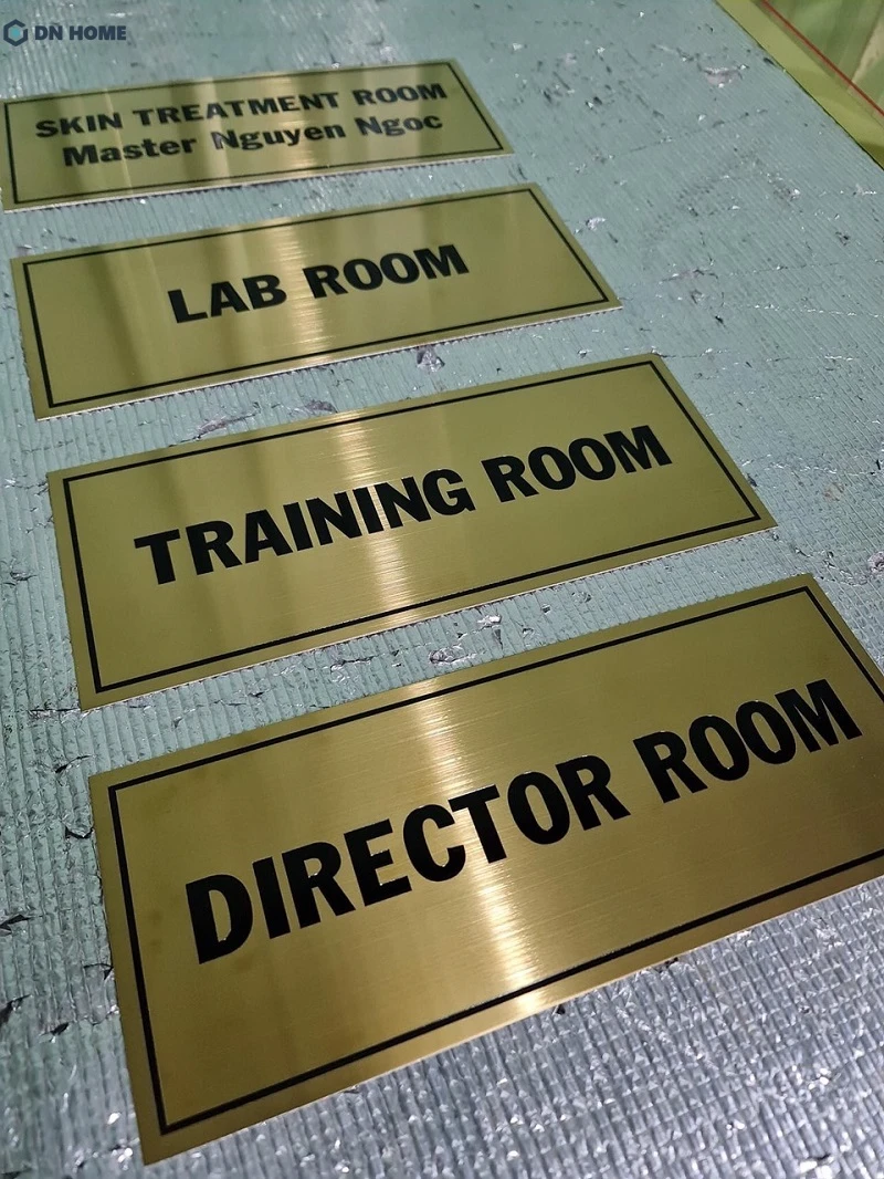 Bảng hiệu inox ăn mòn màu vàng với thiết kế chữ sắc nét, đẹp mắt