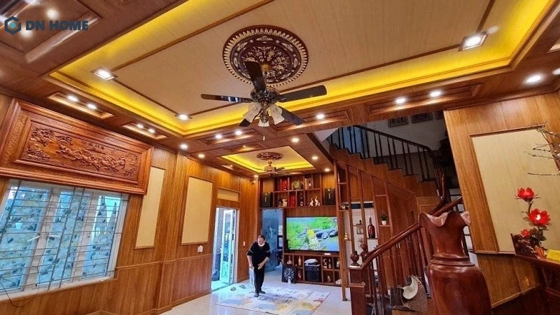 Thiết kế trần nhựa phòng khách giả gỗ kết hợp với ánh sáng vàng tạo nên sự bề thế cho không gian