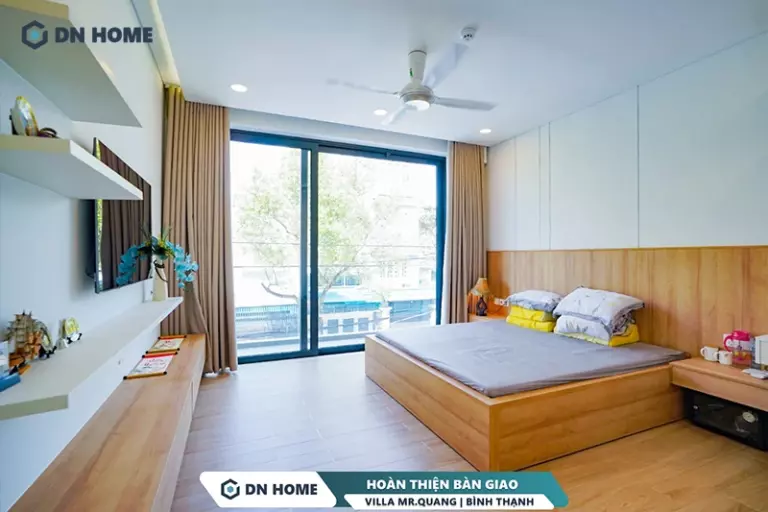 Cửa kính kịch trần và nội thất gỗ chủ đạo tạo nên không gian phòng ngủ ấm cúng, thư giãn