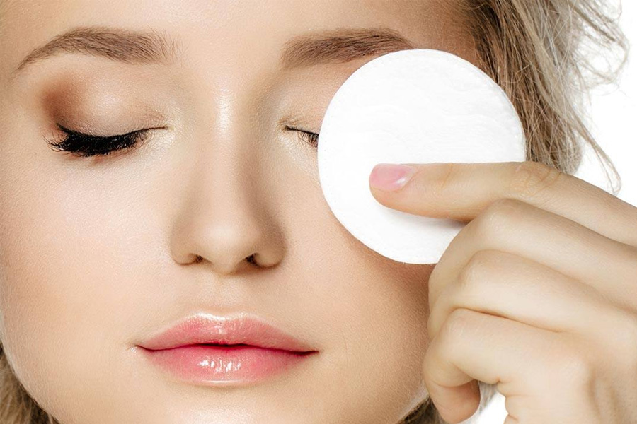 Thấm dầu dừa vào bông tẩy trang và đắp lên mắt