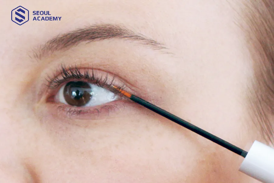 Chấm dầu dừa lên chỗ keo nối để làm tan keo nối mi