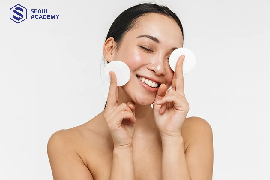 Dùng bông tẩy trang và nước muối sinh lý để làm sạch da mặt, tránh phần chân mày