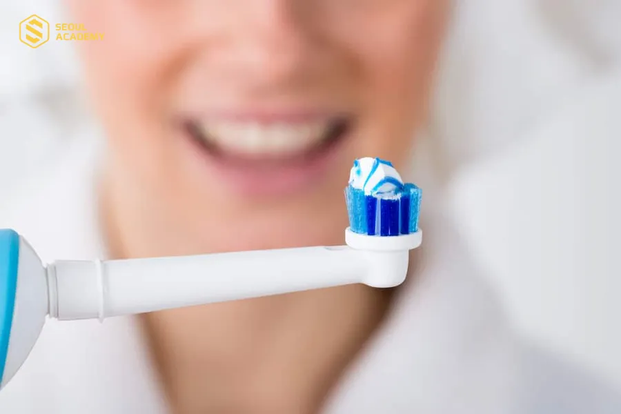 Sử dụng bàn chải nhỏ để chải răng sau khi phun xăm