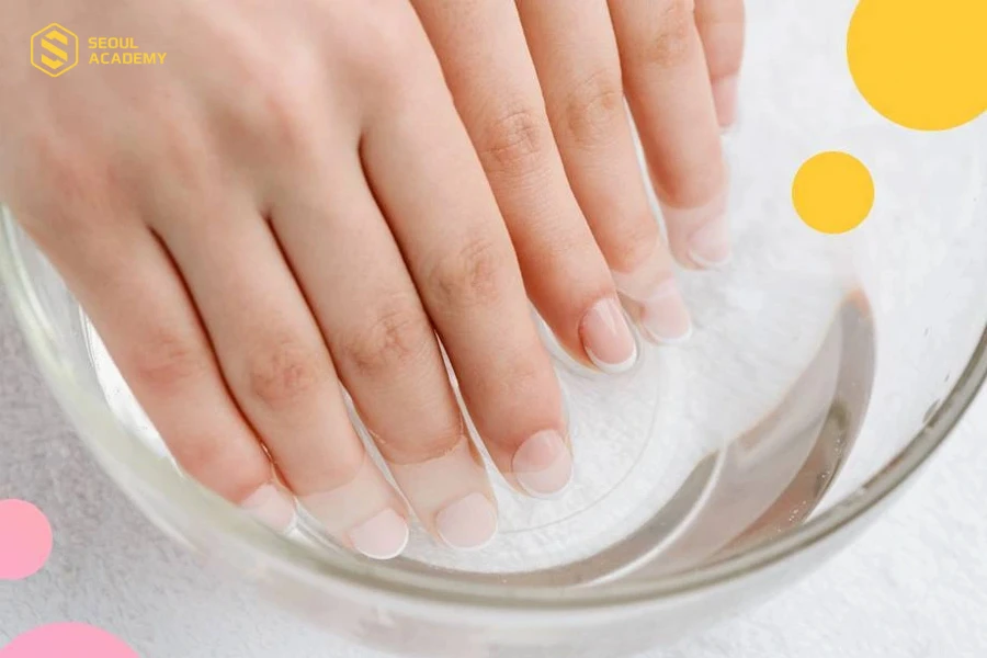 Ngâm tay trong nước ấm để làm mềm móng trước khi cắt