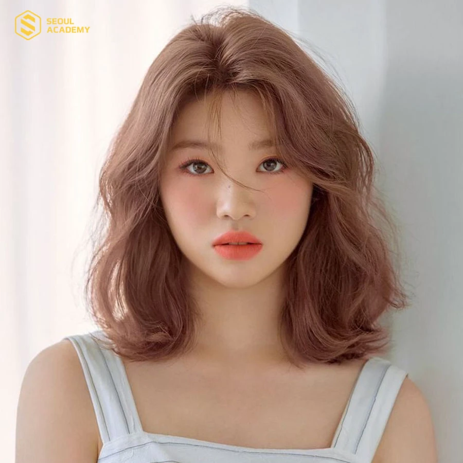 Kiểu tóc xoăn nhẹ ngang vai giúp che đi phần má đầy đặn