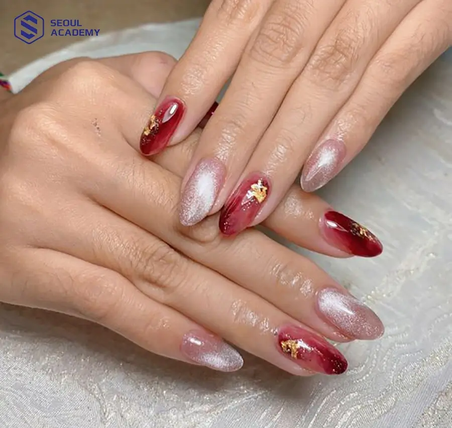 Mẫu nail tone màu đỏ mận với hoạ tiết vân đá và kỹ thuật mắt mèo