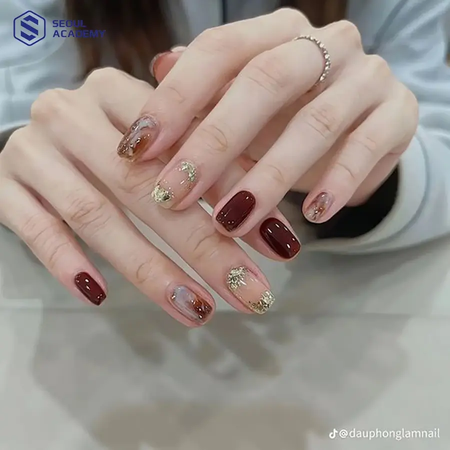 Mẫu nail đỏ mận ẩn xà cừ vàng lấp lánh và huyền diệu