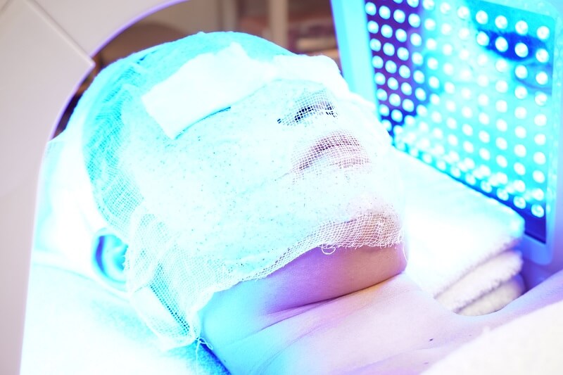 Khách hàng đang được đắp mặt nạ tảo silic kết hợp chiếu ánh sáng xanh