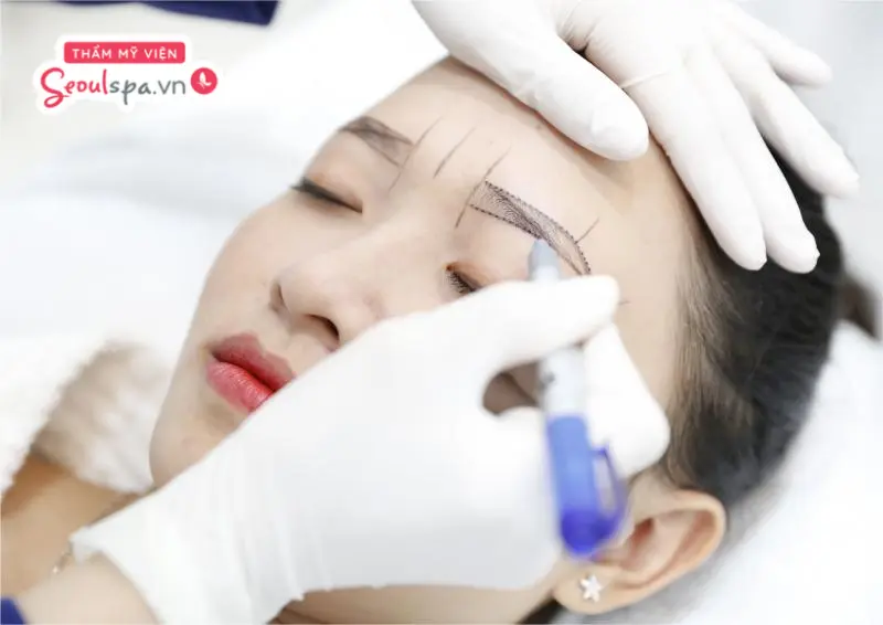 Kỹ thuật viên phác thảo khuôn mày trước khi tiến hành phun mày nano