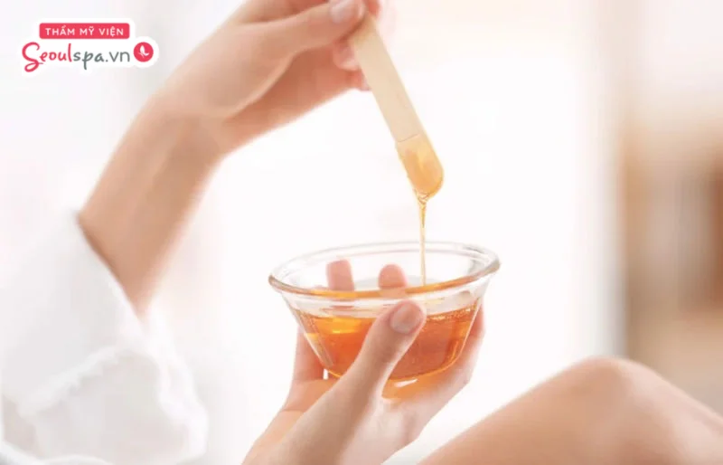 Dùng que lấy sáp và thoa lên vùng cần wax lông